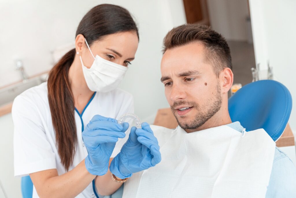 Dentist shows patient Invisalign tray