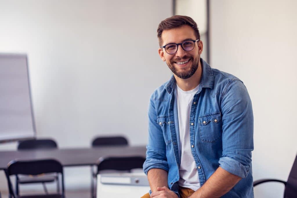 Young,Confident,Entrepreneur,Sitting,In,Modern,Office,Smiling,And,Looking