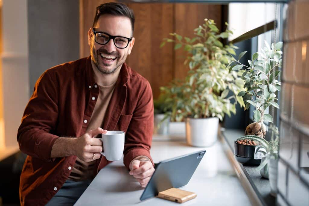 Portrait,Of,Smiling,Confident,Man,Looking,At,Camera,Sitting,Indoors