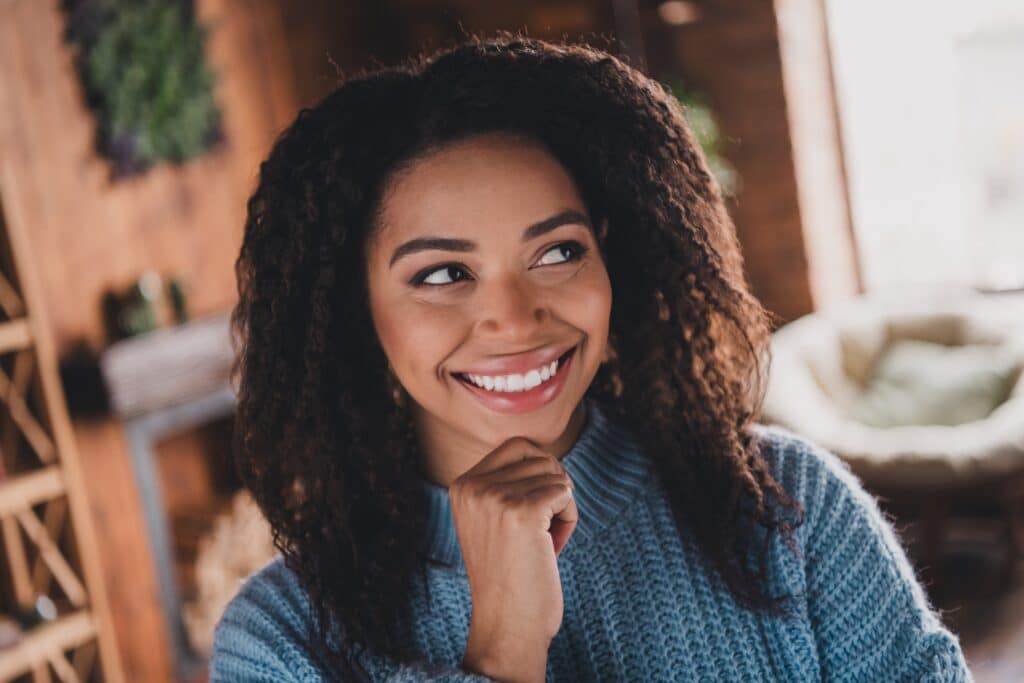 Charming,Young,Woman,With,Afro,Hair,Smiling,In,A,Stylish
