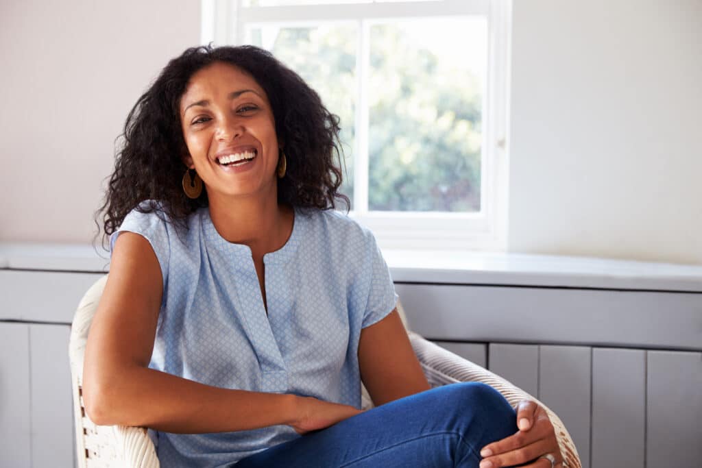 Portrait,Of,Woman,Sitting,In,Chair,At,Home